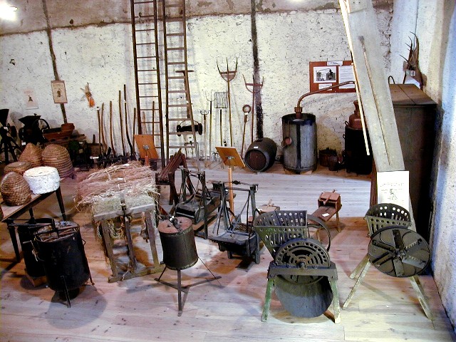 Collection d’outils et machines agricoles anciennes dans le grenier du musée
